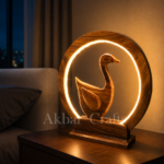 Handcrafted wooden Swan LED ring lamp glowing on a bedside table